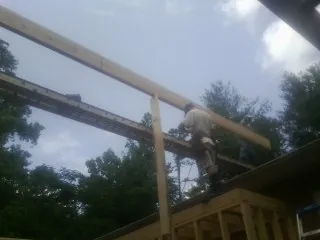 Carpenter setting a ridge beam over a new addition frame — Ice Dam Removal by Roofing Brothers in Front Royal